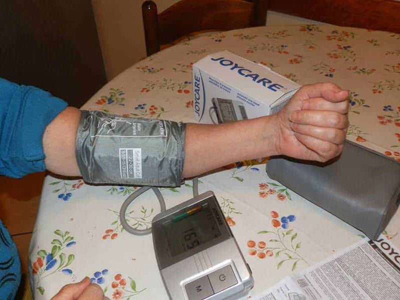 Il misuratore di pressione Joycare-109 su Groupalia 3 Misuratore della pressione sanguigna attaccato al polso durante un controllo medico a casa. Immagine che mostra l'importanza del monitoraggio della salute e dell'autocura.