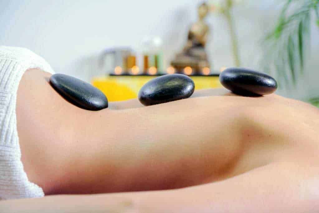 Stones posizionate su schiena durante una sessione di massaggi con pietre calde, in un centro benessere, per il relax e il trattamento termale. Cerimonia di massaggio con pietre calde, trattamento rilassante e terapia olistica.
