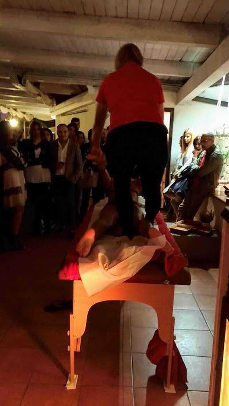 PercorsoHomo Ludens mentre gioca con il corpo in uno spettacolo interattivo a una festa privata. Attori e pubblico si divertono durante l'evento in un ambiente accogliente e ben illuminato.