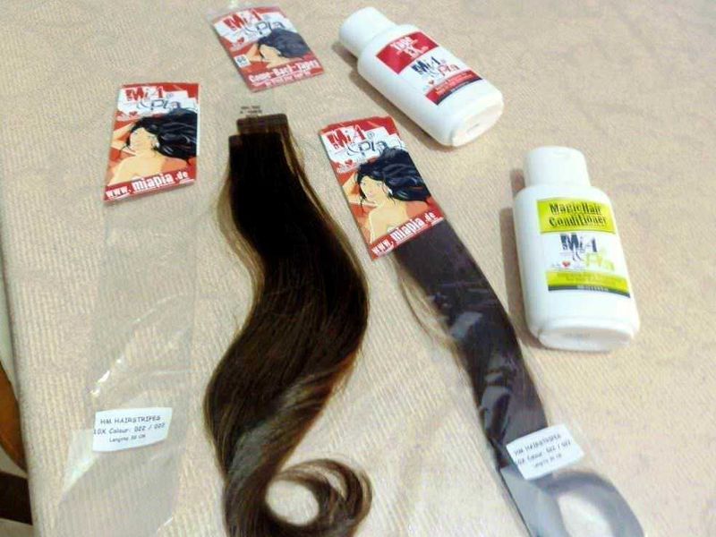 Mia e Pia Extensions Capelli Veri: Guida Completa 5 Guaina per extension capelli, tinta castano scuro, con etichette e boccette di prodotti per la cura dei capelli, mentre si prepara un trattamento di restauro e colorazione.