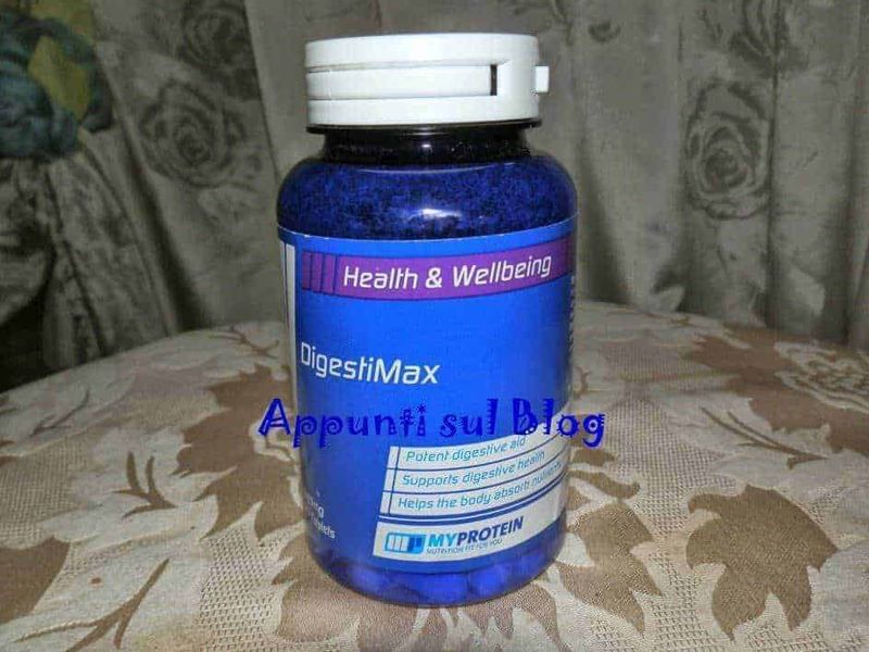 MyProtein integratori alimentari per sportivi 1 Digestive supplement in blue bottle with label highlighting health benefits and protein support for digestive health, placed on patterned tablecloth in indoor setting.
