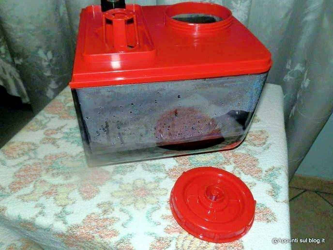 Cattura di un mangia-bende vintage rosso con scatola di plastica e coperchio, utilizzato per conservare medicazioni o materiali medici, su una tovaglia decorata.