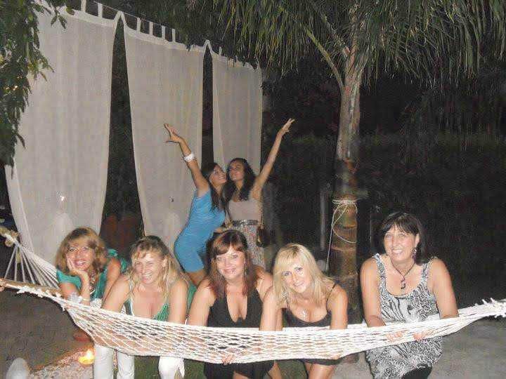 Persone che si divertono all'aperto durante una festa serale con atmosfera festosa e spensierata, riprese con un dispositivo fotografico digitale.