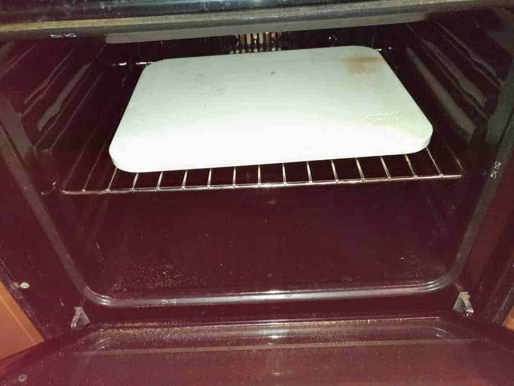 Pannello di cottura in forno con teglia bianca, ideale per cucinare e gratinare alimenti, con spazio regolabile e moderno design.