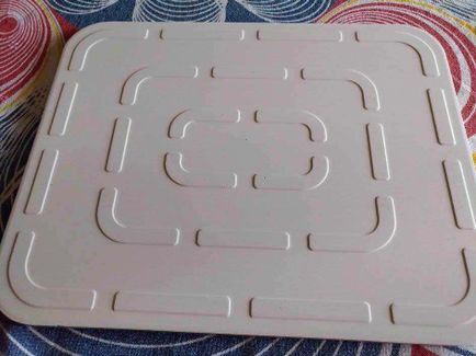 Pizza leggera con pietra refrattaria pizzastein Hans Grill 11 Piatto in plastica bianca con motivo geometrico, ideato per contenere alimenti o snack; superficie liscia con dettagli incavati.