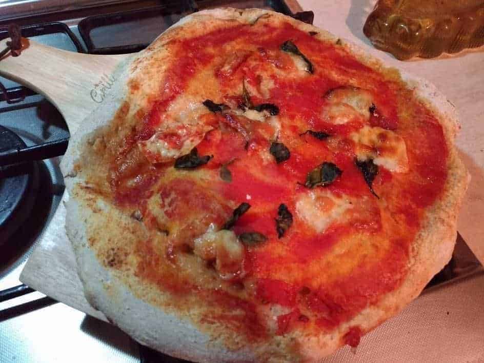 Crosta di pizza napoletana con pomodoro, mozzarella, basilico fresco e olio d'oliva. Pasta morbida e irresistibile, perfetta per gustare una vera pizza italiana fatta in casa o in pizzeria. Olimpo delle pizze tradizionali.