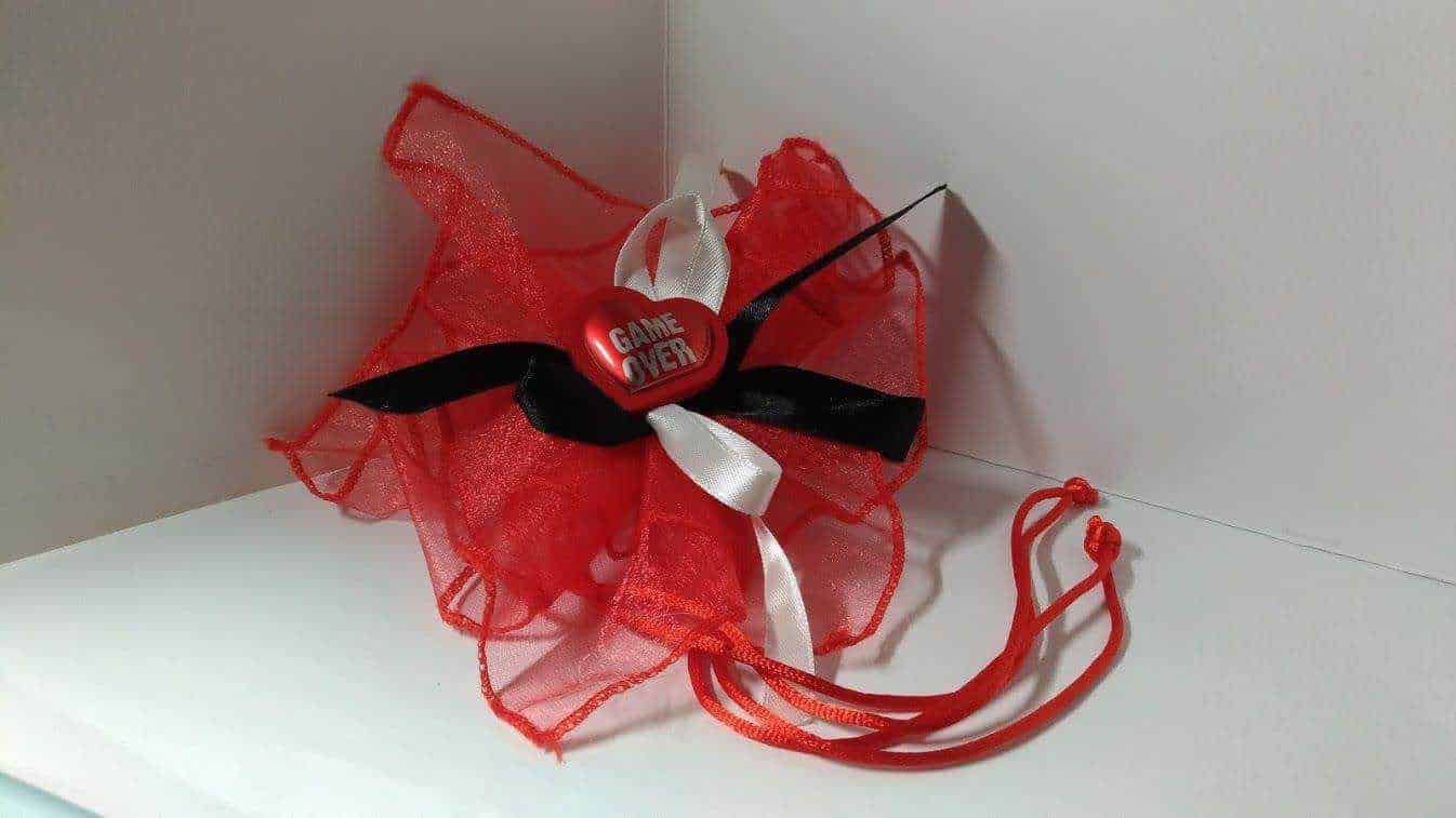 Cuore rosso con fiocco bianco, nero e un'imbottitura di rete rossa, decorato con il testo "Game Over", perfetto come regalo romantico o decorazione di San Valentino.