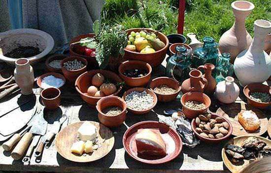 Vasi di terracotta e ceramica, prodotti artigianali e spezie su un banco da mercato all'aperto, stile rustico e naturale, perfetto per appassionati di cibo genuino e artigianato locale.