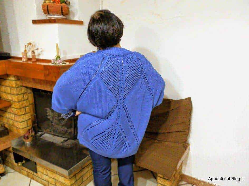Veste blu con dettagli intrecciati e tessuto a rete, appesa su appendiabiti in stile vintage, con tag cucito a mano, ideale per look casual e alla moda.