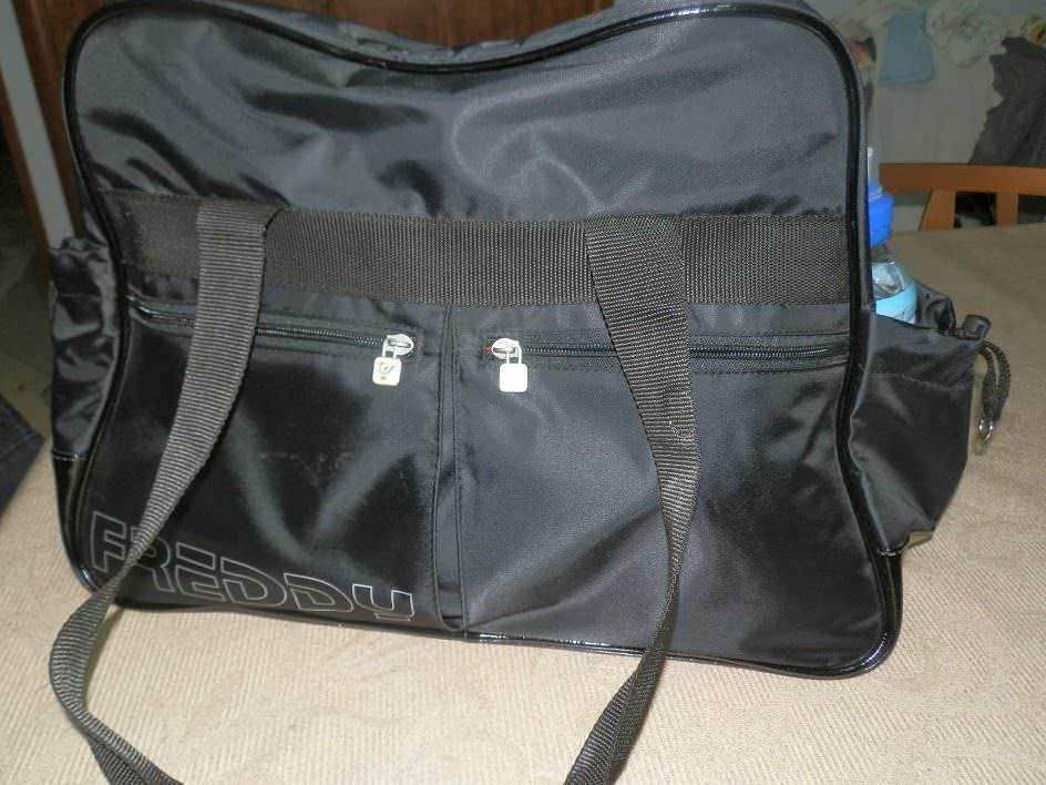 Borsa da viaggio nera con tasche e tracolla, ideale per sport e trasferte, in tessuto resistente e capiente, con scomparti organizzati e chiusure sicure per trasportare attrezzature e vestiti.