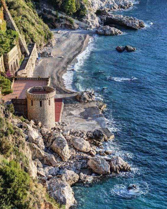 Vista panoramica di Capo d'Orso della costa amalfitana con scogliera, mare blu e ville fronte mare in un paesaggio mediterraneo. Tranquillo scenario di mare e natura in Italia.