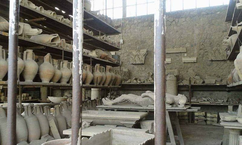 Eruzione Vesuvio 79 d.C.: 5 Cose che non sai sulla fine di Pompei ed Ercolano 4 Vasi in ceramica e resti archeologici in un laboratorio di restauro di antichi reperti archeologici, ambiente di conservazione e studio degli oggetti storici in terracotta.