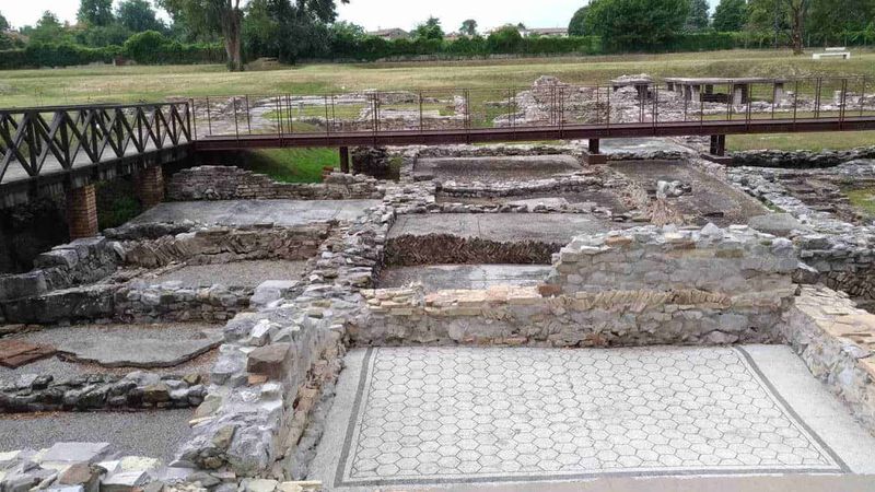 Friuli Venezia Giulia tour nei borghi e province della terra di confine 8 Resti archeologici romani con pavimentazione in mosaico, area di scavi storici e ponte in ferro, sito archeologico a cielo aperto, patrimonio culturale e storico italiano, visite archeologiche pubbliche.