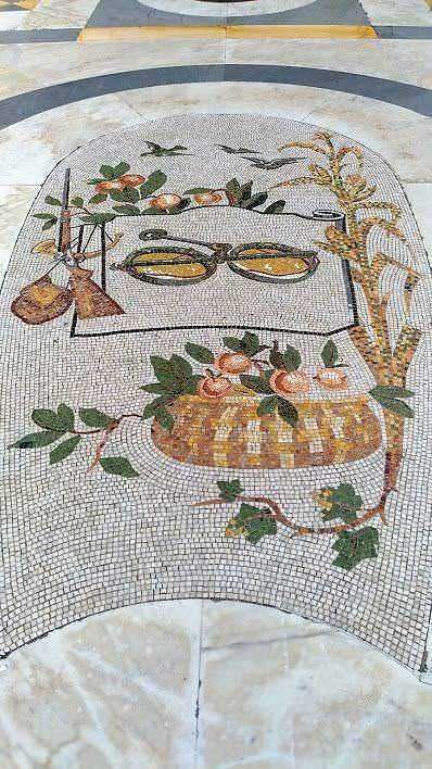 Occhiali da sole su mosaico artistico con fiori e piante, decorazione colorata e dettagliata, perfetta per blog e articoli di arte e design.