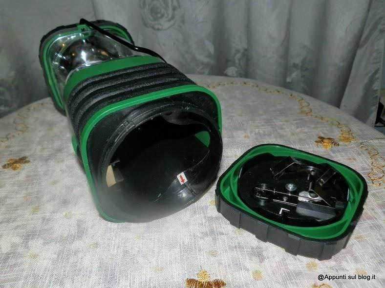 Una scatola di pesca con accessori e gadget per la pesca sportiva, posizionata su un tavolo con tovaglia bianca con dettagli dorati.