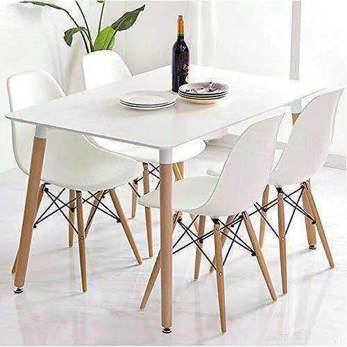 Minimalista tavolo da pranzo con sedie bianche e decorazione semplice, ideale per ambienti moderni e luminosi, perfetto per cene familiari e incontri conviviali.