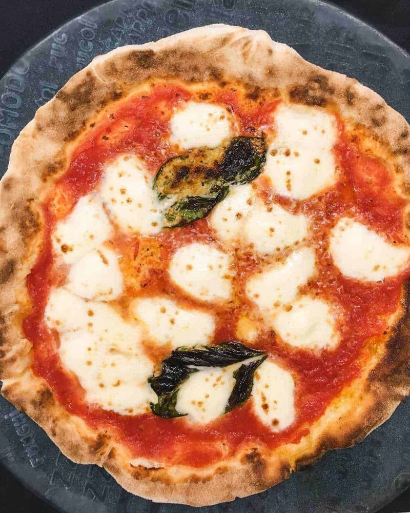 Napoli 12 siti tra arte, pizza e caffè espresso 14 Un grande bunker sotterraneo abbandonato con pareti di cemento e biciclette parcheggiate, illuminato da luci calde, che mostra un’architettura unica e suggestiva.