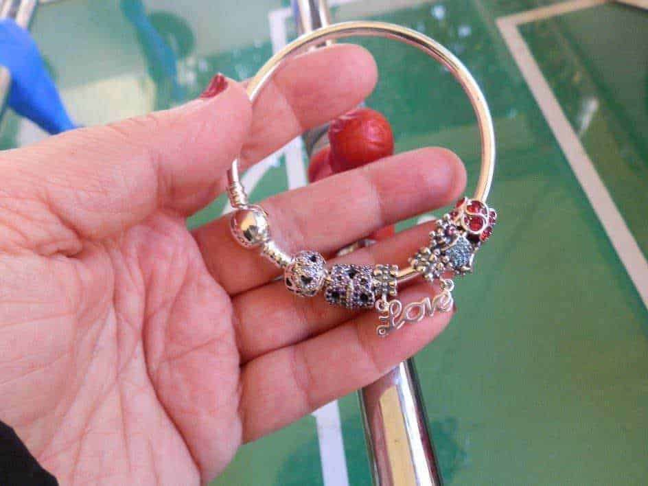 Bracciale charm con pendenti in argento e cristalli, accessorio elegante e femminile.