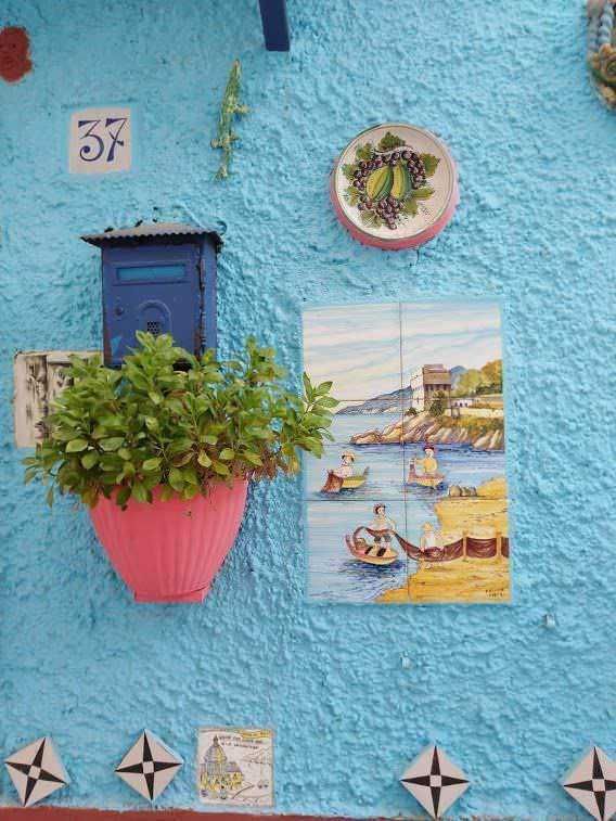 Spiaggia di Positano, costa amalfitana, con case colorate su scogliera, promontorio suggestivo e mare tranquillo, perfetta meta per vacanze estive e relax in Italia.
