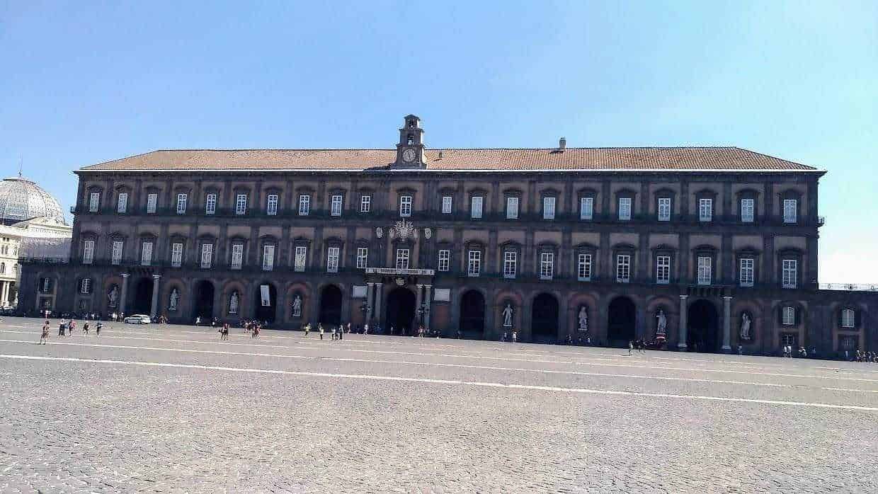 Palazzo storico in piazza con architettura classica, situato nel cuore di Napoli, Italia, esempio di edifici storici e monumenti italiani.