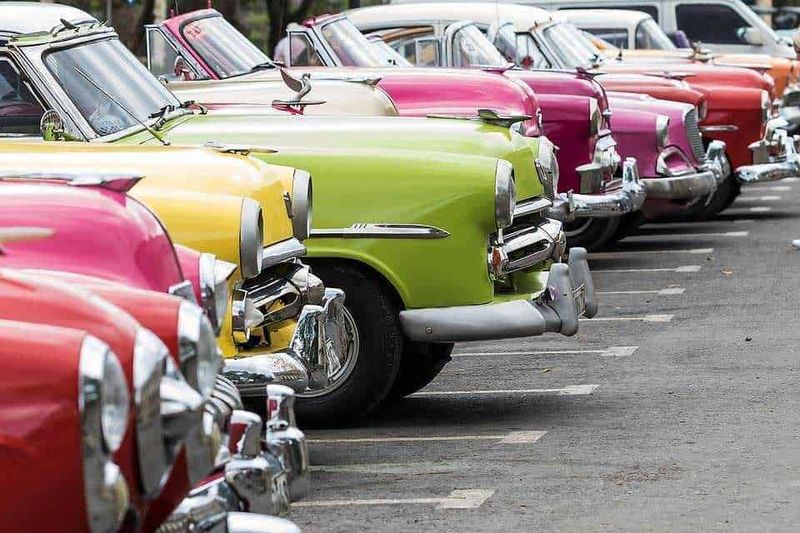 Storia del Taxi: dall'Hansom cab dell'Ottocento all'era moderna 7 Taxi d'epoca parcheggiati in fila in un evento di auto d'epoca.