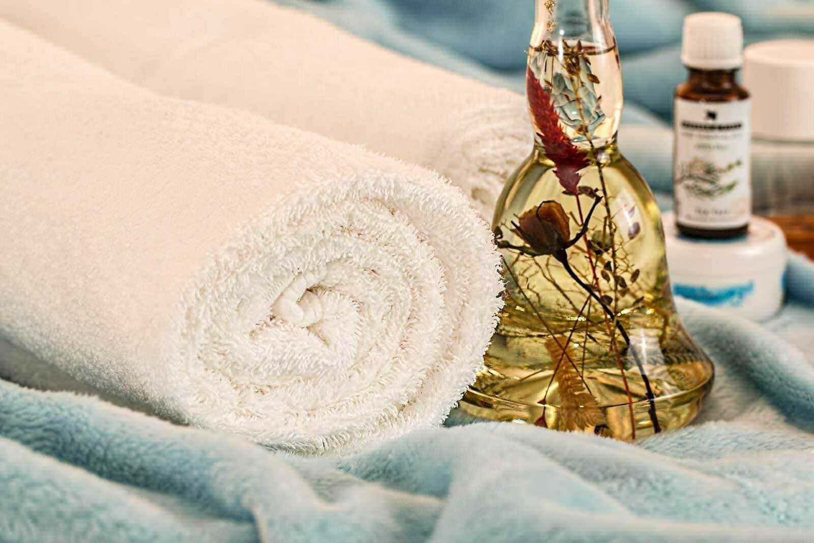 Profumo rilassante di oli essenziali con tovagliolo di spugna e flacone di olio aromatico per massaggi e aromaterapia.
