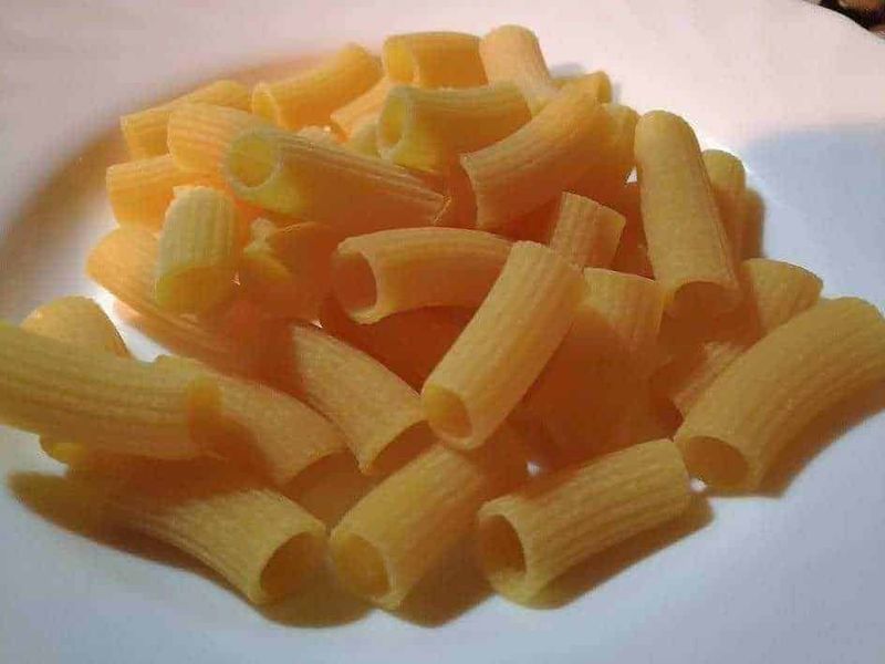 Pasta Borella, subioti e bigoli de Bassan sulla nostra tavola 3 Pasta fresca con ragù di carne e verdure, piatto tradizionale italiano, cucinato e servito in un piatto decorato con fiore e colori vivaci, forchetta a fianco, atmosfera casalinga e autentica.