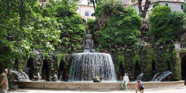 Fontana pubblica circondata da alberi verdi, zona di relax nel centro città, ideale per passeggiate e fotografie, un luogo di pace e natura urbana adatto a residenti e turisti.