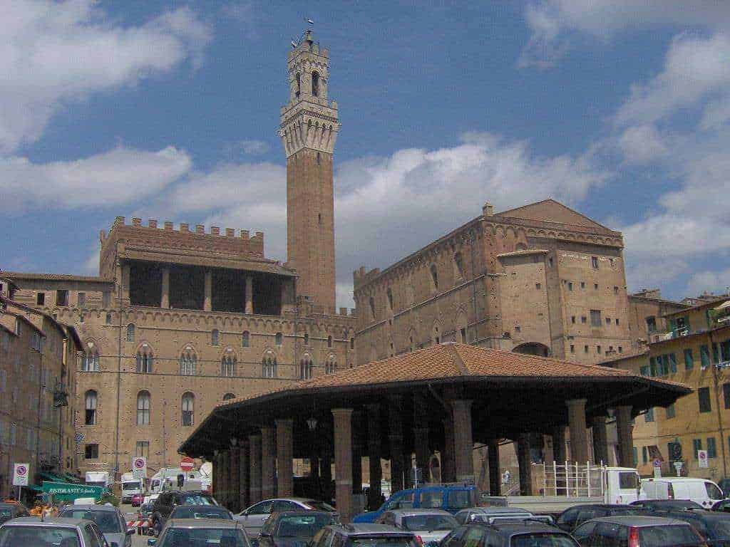 Castello di Firenze, Torre di Arnolfo e piazza con auto e bus, scenario urbano storico.