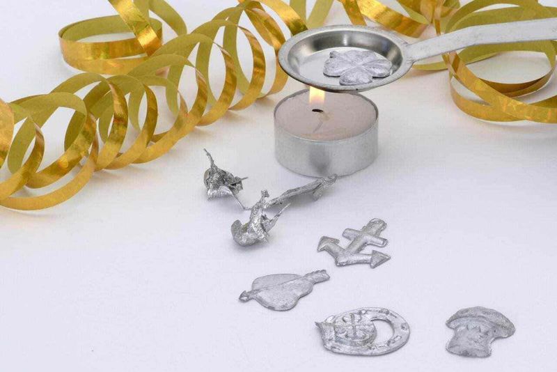 13 tradizioni di Capodanno da tutto il mondo 4 Decorazioni di Capodanno con candele, teddy bear, orsetti di cioccolato e festoni dorati per un’immagine di celebrazione e festa. Perfetto per articoli blog su eventi e feste di fine anno.