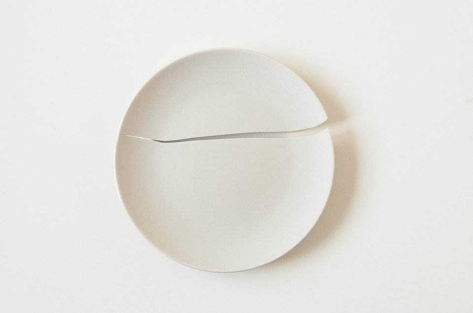 Ceramica bianca minimalista con crepa decorativa, stile elegante e moderno per la casa. Design pulito e semplice per ambienti sofisticati e di tendenza.