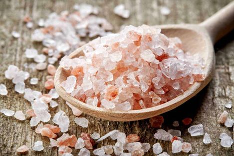 Cloruro di sodio o sale iodato nella dieta? 3 Sale rosa dell'Himalaya sulla cucchiaiata di legno, sale naturale e salgemma rosa, prodotto alimentare salutare, condimento naturale per cucina sana.