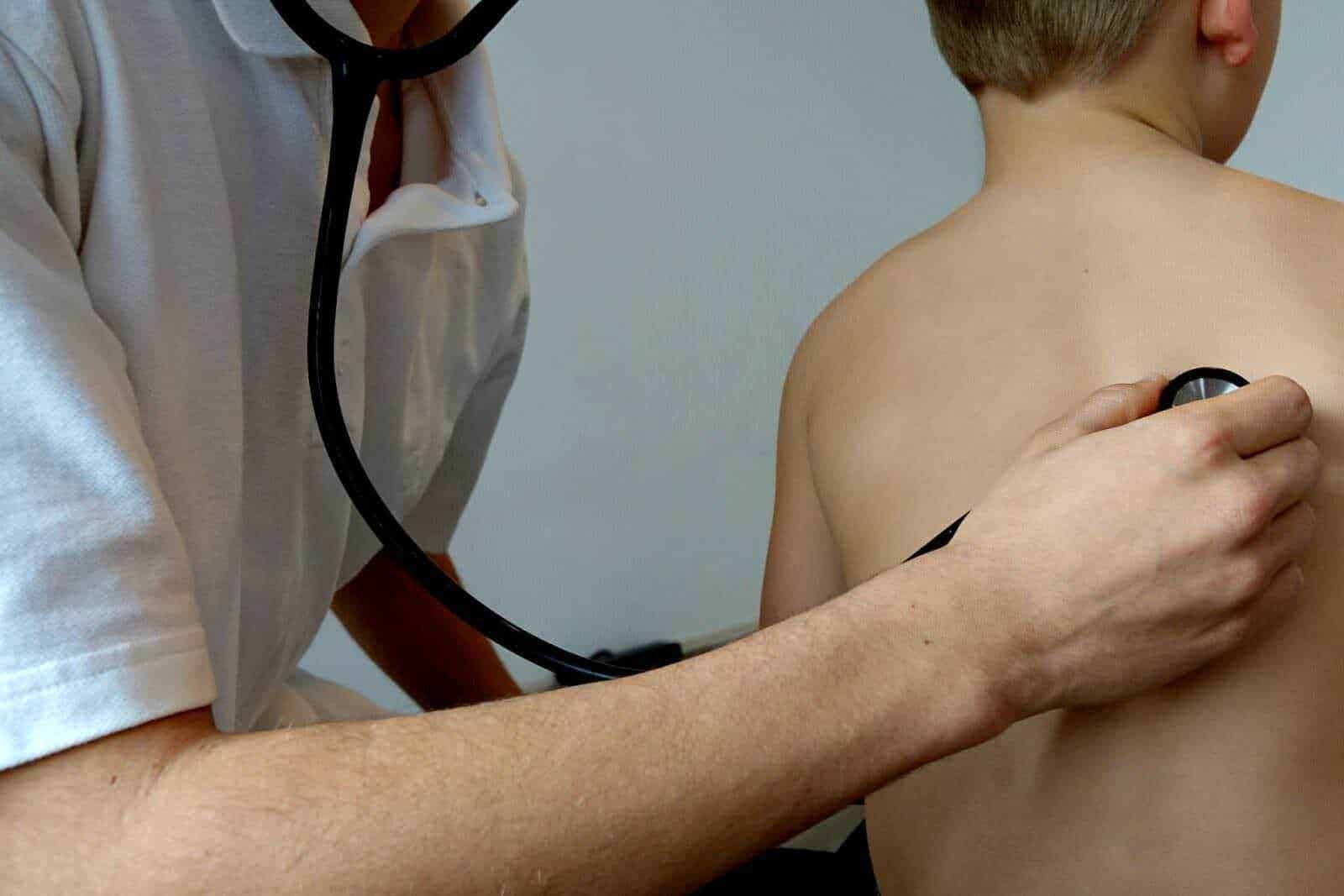 Diagnosi medica con stetoscopio su paziente giovane, visita in ambulatorio medico, controllo cardiovascolare, immagini di attività medica, assistenza sanitaria, immagine di medicina moderna, professionalità clinica, prevenzione sanitaria.
