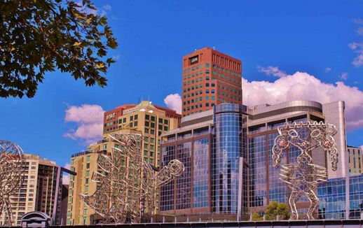 Amanti dell'Arte visiva, scopri 12 città culturali 16 Grattacieli moderni con architettura elegante e sculture artistiche in metallo, città dinamica con edifici alti e cielo azzurro, design urbano e skyline contemporaneo.