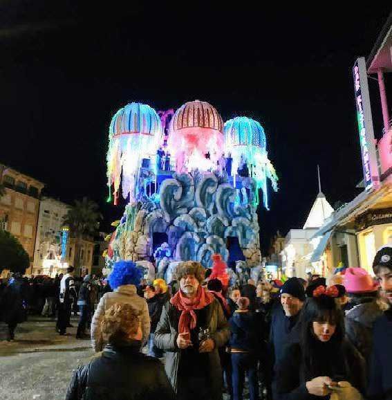 Colorato evviva diurnale con fontane luminose e festa in strada, persone felici e musica dal vivo, atmosfera festosa e vivace, luci natalizie e decorazioni nelle vie cittadine.
