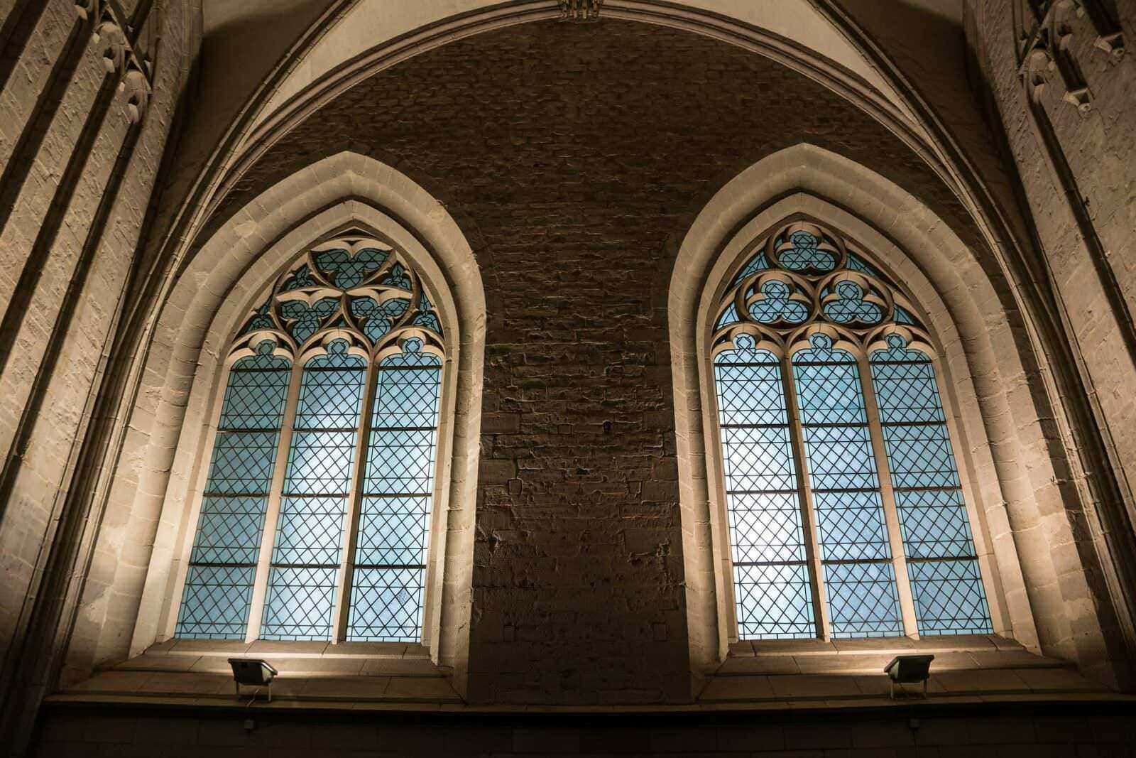 Vetrate istoriche in stile gotico all’interno di una chiesa o cattedrale, con dettagli artistici e architettonici di grande valore.