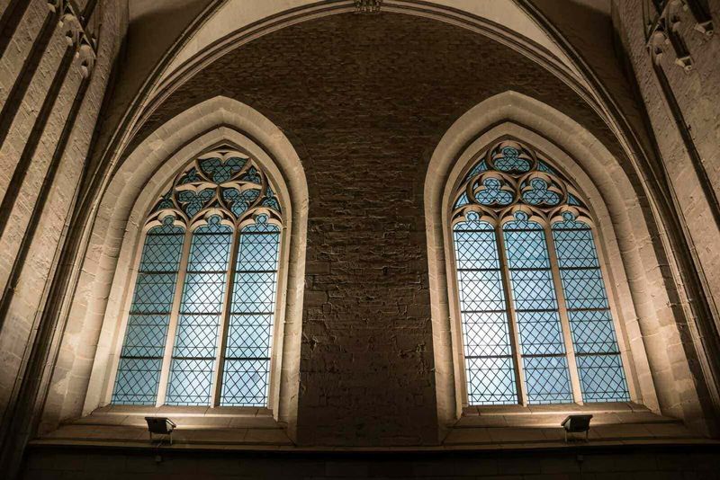 Città medievale XI secolo tra mura fortificate: aspetto e vita quotidiana 7 Vetrate istoriche in stile gotico all’interno di una chiesa o cattedrale, con dettagli artistici e architettonici di grande valore.