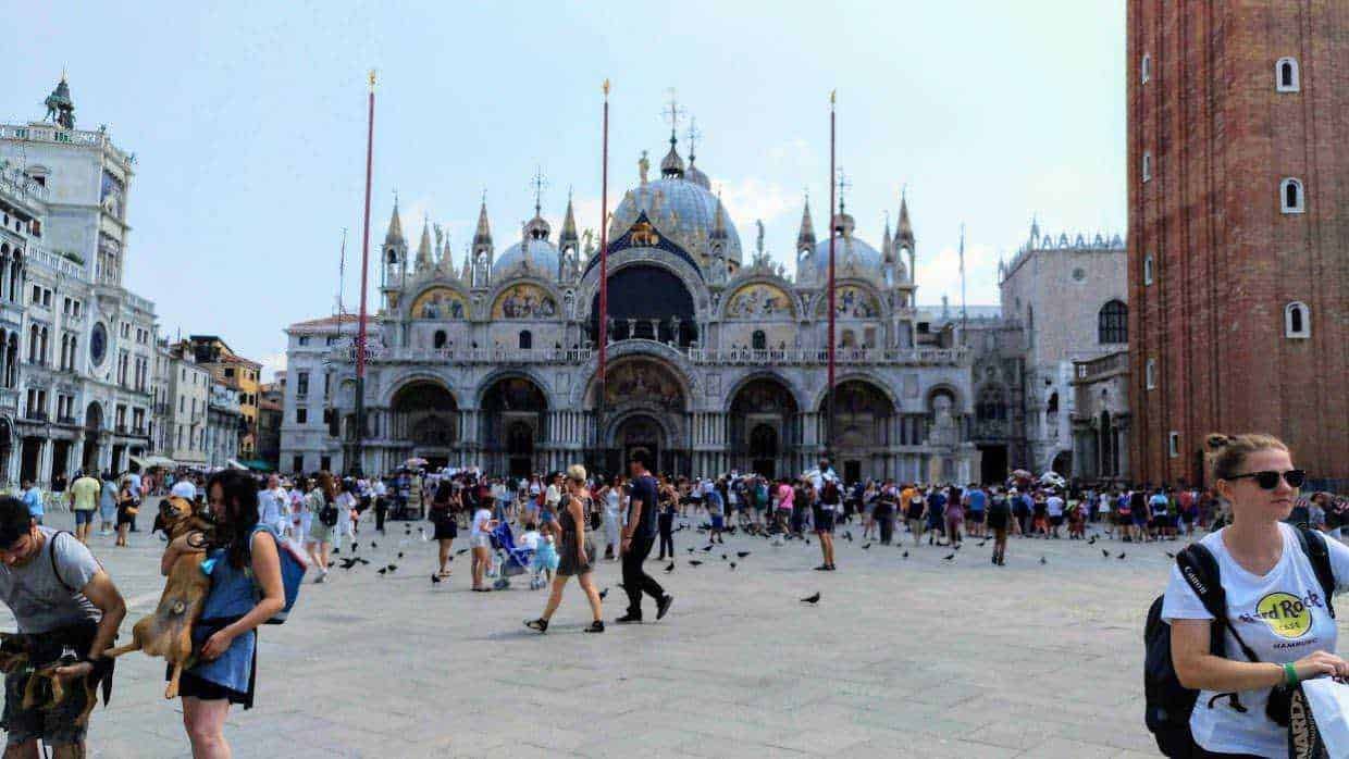 Venedig Piazza San Marco con Basilica, turisti e uccelli, scena affascinante di una delle principali attrazioni storiche italiane.