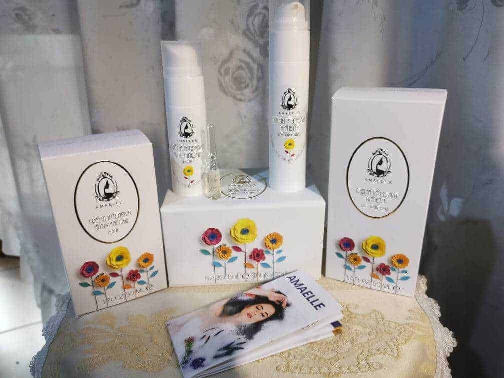 Cosmesi naturale italiana con acido ialuronico: Fitosofia, linea Amaelle cosmesi naturale italiana. Crema antirughe e cosmetici naturali Amaelle con confezioni eleganti e fiori colorati, sulla tavola decorata, ideale per cura della pelle e routine di bellezza, rappresentazione di prodotti di qualità.