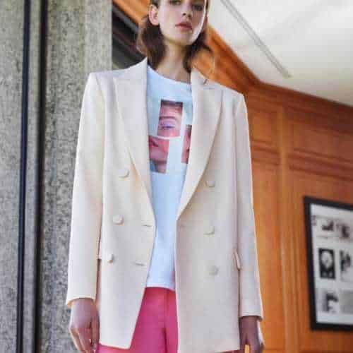 Elegante donna in giacca beige e t-shirt con stampa artistica, stile sofisticato e alla moda, adatto alle tendenze moda primavera-estate 2023, look casual chic.