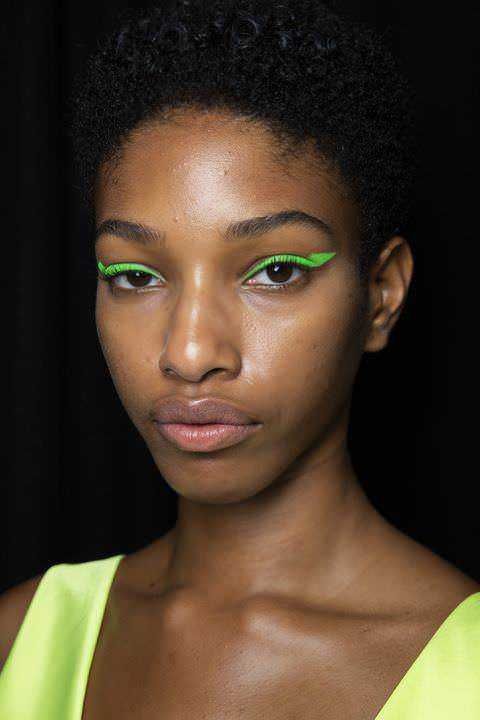 Line 1: elegante donna con trucco occhi fluorescente verde, stile moderno e di tendenza.