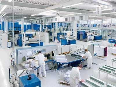 Print24, tipografia online dai prezzi modici! 3 Macchinari industriali all'avanguardia in un impianto di produzione high-tech, con lavoratori qualificati che gestiscono le attrezzature per garantire efficienza e qualità del prodotto finito.