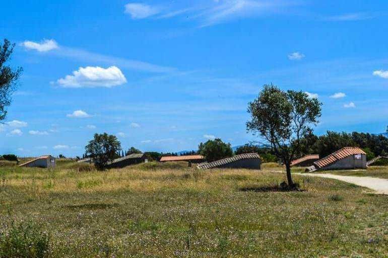 Vista rurale con case e alberi sotto un cielo azzurro, perfetta per appunti sul blog su paesaggi, natura e fotografiain ambienti italiani.