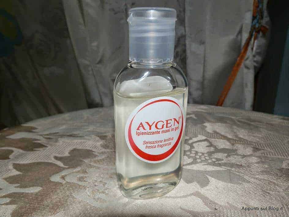 Agen gel igienizzante mani in gel su tavolo con tovaglia ricamata, texture di stoffa decorativa, ambientazione casalinga, mostra un prodotto per l’igiene personale e disinfettante per le mani.