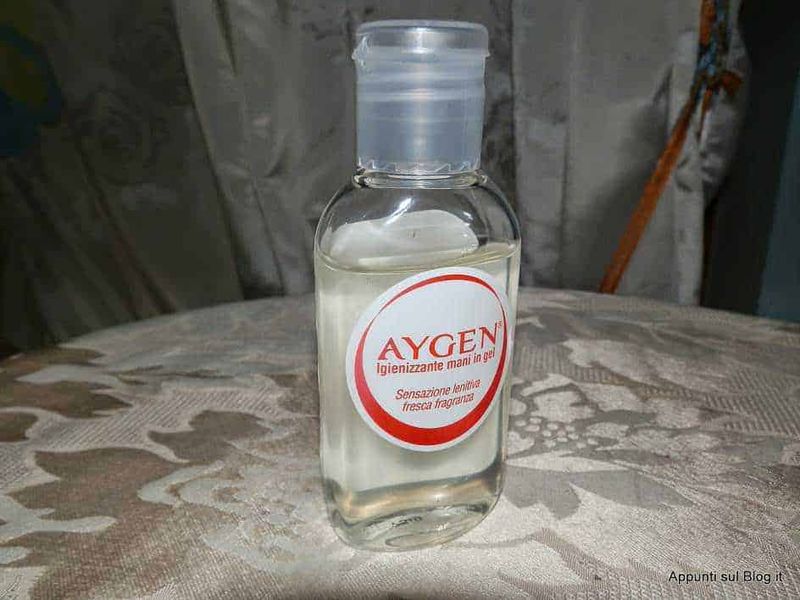 Gel capelli caap 3m, lozioni per prevenire la caduta dei capelli 3 Agen gel igienizzante mani in gel su tavolo con tovaglia ricamata, texture di stoffa decorativa, ambientazione casalinga, mostra un prodotto per l’igiene personale e disinfettante per le mani.