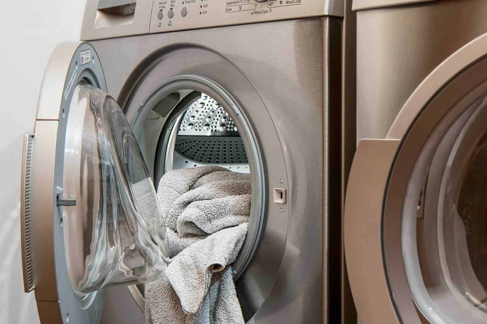 Lavatrice moderna aperta con asciugamani in cotone morbido e spugnosos, dettaglio di elettrodomestici in casa, tecnologia per bucato, cura dei tessuti, lavaggio e igiene domestica.