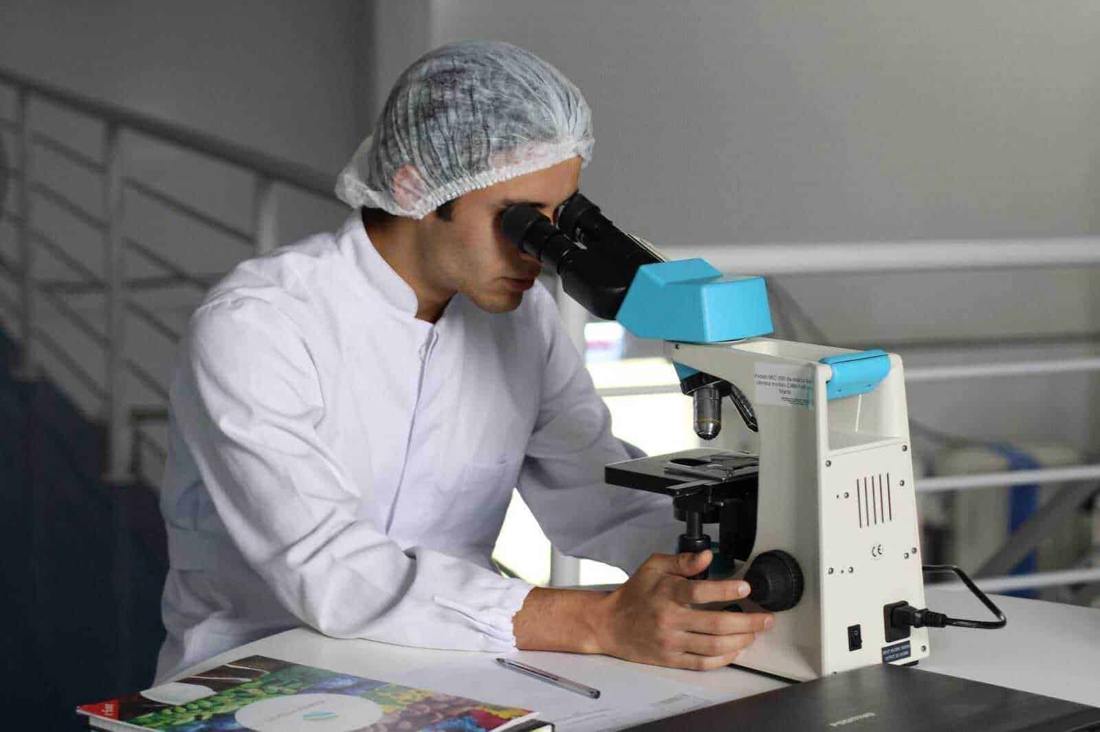 Microscopio professionale in laboratorio, ricercatore che analizza campioni biologici, tecnologia scientifica, innovazione in ricerca, immagine di scienza e biotecnologia.