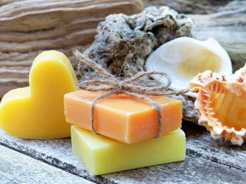 7 detergenti fai da te contro gli odori sgradevoli in casa, facili ed efficaci! 3 Sapone naturale fatto a mano con profumi e colori delicati, perfetto per la cura della pelle e il benessere, presentato su superficie di legno rustico come decorazione naturale.