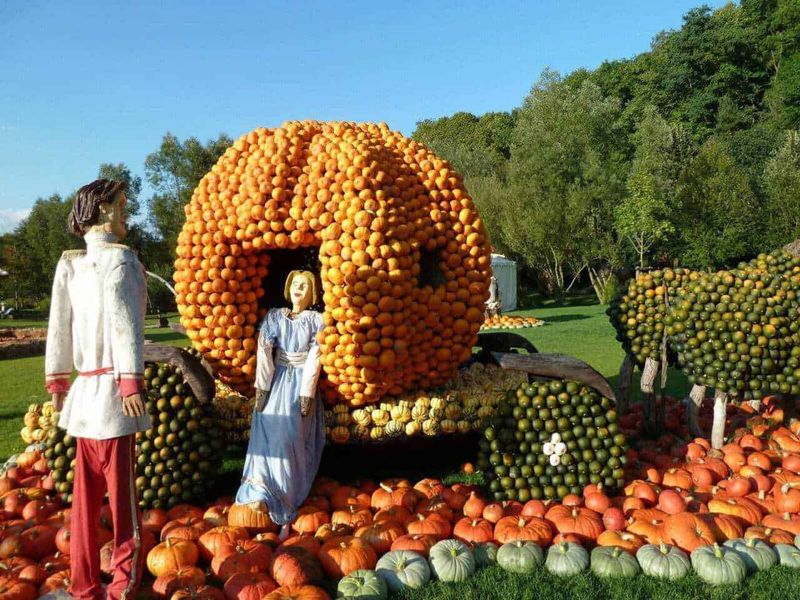 Finali tragici favole bambini: 7 finali originali e inquietanti 3 Cantiere di zucche e ortaggi decorativi in forma di carrozza, in un parco, con figure di persone in abiti tradizionali in mostra, ambiente autunnale colorato.