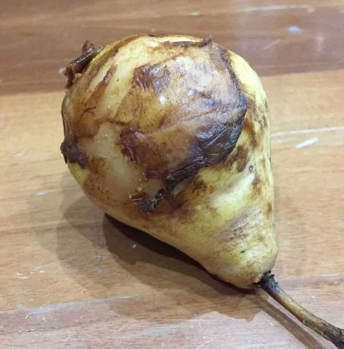 Patata con ammaccature e marciume sulla superficie, pronta per la preparazione culinaria o per il compostaggio, rappresenta un esempio di verdura deteriorata.